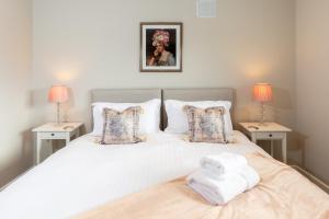 a bedroom with a large white bed with two lamps at Stag Lodge at Sherwood in Edwinstowe