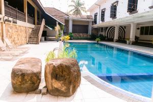 a swimming pool with two large rocks next to a house at Romantic garden hotel in Negombo