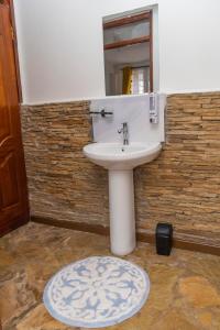 a bathroom with a white sink and a mirror at Elevate by African Manor in Bungoma