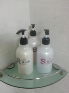 three white bottles on a glass shelf in a bathroom at Hansol Hotel in Gyeongju