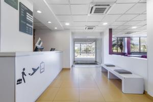 un vestíbulo de oficina con una zona de espera con un banco en City Express Junior by Marriott Tuxtla Gutierrez Poliforum, en Tuxtla Gutiérrez