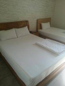 two beds in a room with white sheets at Hansol Hotel in Gyeongju