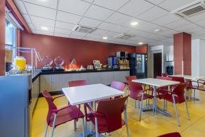 un restaurante con mesas blancas y sillas rojas en City Express Junior by Marriott Tuxtla Gutierrez Poliforum, en Tuxtla Gutiérrez