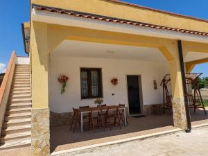 un patio con tavolo e sedie in una casa di Villa La Sosta - 150m dal mare - Patio Privato e Areal Relax ad Arenella