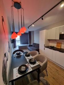 Apartamenty Panorama في لودز: مطبخ وغرفة معيشة مع طاولة وكراسي