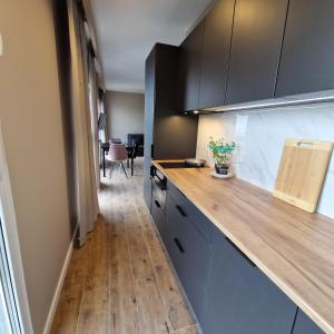 Apartamenty Panorama في لودز: مطبخ مع كونتر خشبي في الغرفة