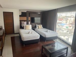 a hotel room with two beds and a window at Nordwind Hotel in Chiang Mai