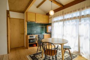 eine Küche mit einem Tisch und Stühlen im Zimmer in der Unterkunft Yanagawa Guest House Horiwari in Yanagawa