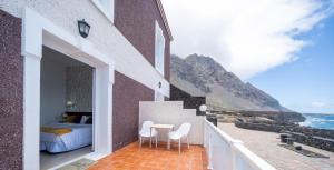a bedroom with a bed and a table and chairs on a balcony at Balneario Pozo de la Salud in Sabinosa