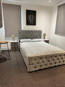 a bedroom with a large bed with a tufted headboard at 2 bed Home away from home tooting London in London