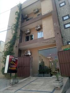 a building with a sign in front of it at Second Home Family Hotel in Lahore