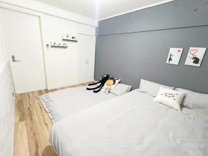 1 dormitorio con cama blanca y pared azul en 高田馬場7人可 02 en Tokio