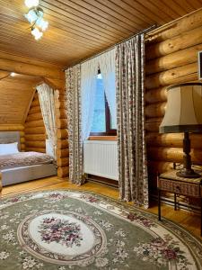 1 dormitorio en una cabaña de madera con cama y ventana en Cottage PolyaNitsa окремий котедж з каміном en Bukovel