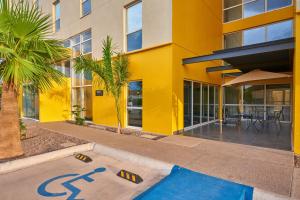 un edificio giallo con un cartello stradale sul marciapiede di City Express by Marriott San José Costa Rica a San José