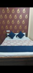 uma cama com almofadas azuis num quarto em Krishna paying guest house em Varanasi