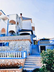 una casa con escaleras azules delante en Villa Sunrise With Sea View, en Rogač