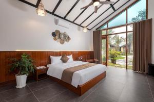 ein Schlafzimmer mit einem großen Bett und einem großen Fenster in der Unterkunft La Vento Resort Ninh Bình in Ninh Bình