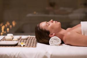 a woman laying on a bed in a massage room at Hotel Miramare - SPA & Suites - Breakfast & Brunch Until 13-00 in Cervia