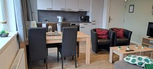 een woonkamer met een tafel en stoelen en een keuken bij 105,4 appartement 200m van strand in Westkapelle