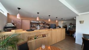 a restaurant with a bar with bottles on the counter at Le Relais de la Sans Fond in Fénay