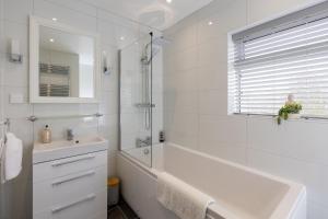 een witte badkamer met een bad en een wastafel bij Stag Lodge at Sherwood in Edwinstowe