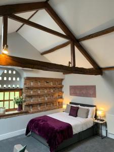 a bedroom with a large bed with a brick wall at Studio 3B The Carriage House York 6m Village Location in York