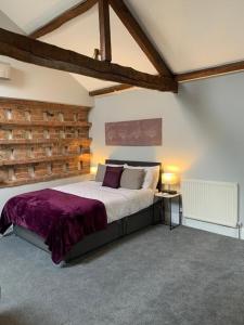 een slaapkamer met een groot bed en een houten muur bij Studio 3B The Carriage House York 6m Village Location in York