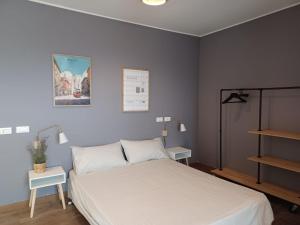 a bedroom with a bed and two tables and a shelf at Sui Generis penthouse with terraces in Milan