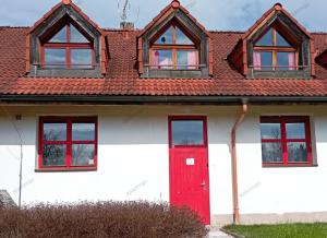 a white house with a red door and windows at Apartmán Nepomuk in Nepomuk
