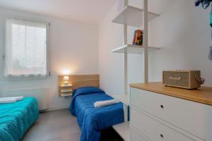 a bedroom with two blue beds and a window at West Side Bologna Apartment in Bologna