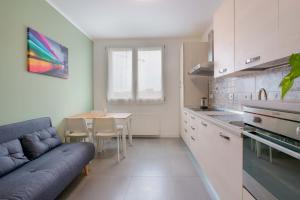 a kitchen with a couch and a table in a room at West Side Bologna Apartment in Bologna