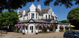 a white house with a clock on top of it at Tolroy Manor Holiday Park in Hayle