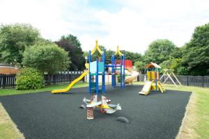 a park with a playground with a slide at Tolroy Manor Holiday Park in Hayle