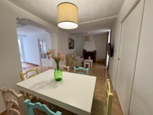 a dining room table with a vase of flowers on it at CASA MARÍA LA ROMANA in Torres