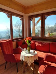 una sala de estar con sofás rojos y una mesa con flores en Pieśń Poranka Domek, en Łysina