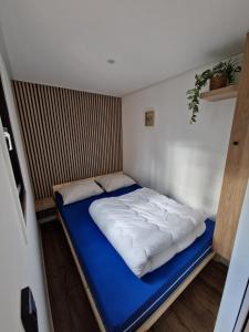 a bed in a small room with a blue mattress at De Eekhoorn in Zuidwolde