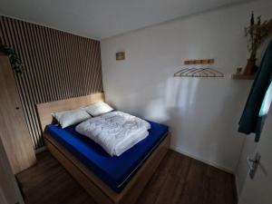 a small bedroom with a bed with a blue mattress at De Eekhoorn in Zuidwolde