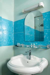 bagno con lavandino bianco e specchio di CINCINNATI HOTEL YAOUNDE a Yaoundé