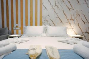 un letto bianco con sopra asciugamani di Electra Suites a Samotracia