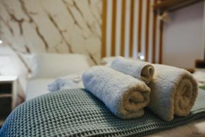 een stapel handdoeken bovenop een bed bij Electra Suites in Samothráki