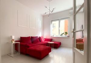 a living room with a red couch and a window at Vitosha Downtown Apartments in Sofia