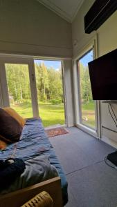 um quarto com uma cama e uma grande porta de vidro deslizante em Hirsimökki kansallispuistossa em Espoo