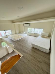 two beds in a room with two windows at Star-Moon B&B Green Island in Green Island