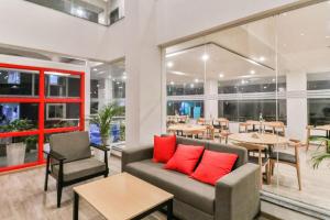 - un restaurant avec des oreillers rouges sur un canapé et des tables dans l'établissement Townhouse Reva College University, à Yelahanka