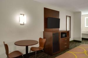 a hotel room with a table and a tv at Super 8 by Wyndham Pearl/Jackson/East in Pearl