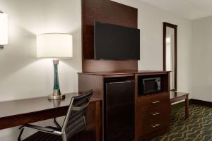 a hotel room with a desk with a computer and a tv at Super 8 by Wyndham Pearl/Jackson/East in Pearl