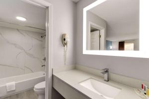 a white bathroom with a sink and a phone at Super 8 by Wyndham Pearl/Jackson/East in Pearl +29 photos
