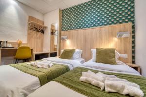 a hotel room with two beds with towels on them at Hôtel Escurial - Centre Gare in Metz