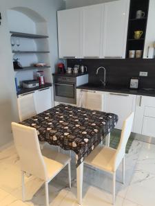 uma cozinha com uma mesa e 2 cadeiras e uma cozinha com armários brancos em MARCO'S HOUSE em Sanremo