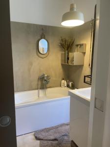 baño con bañera grande y lavamanos en Appartement cosy, en Le Perreux-Sur-Marne